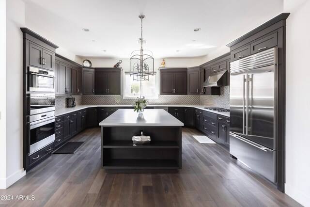 kitchen featuring a center island, hanging light fixtures, stainless steel appliances, tasteful backsplash, and dark hardwood / wood-style floors