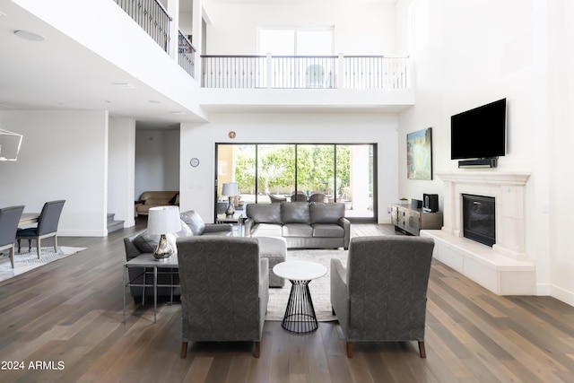 living room featuring a towering ceiling and dark hardwood / wood-style floors