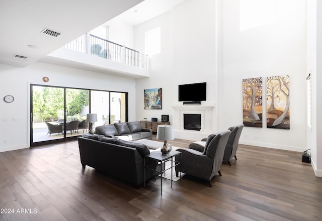 living room with a towering ceiling and dark hardwood / wood-style floors