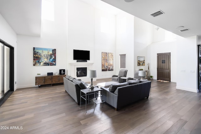 living room with a towering ceiling and hardwood / wood-style flooring