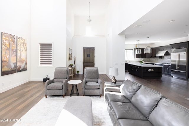 living room with dark wood-type flooring and a high ceiling