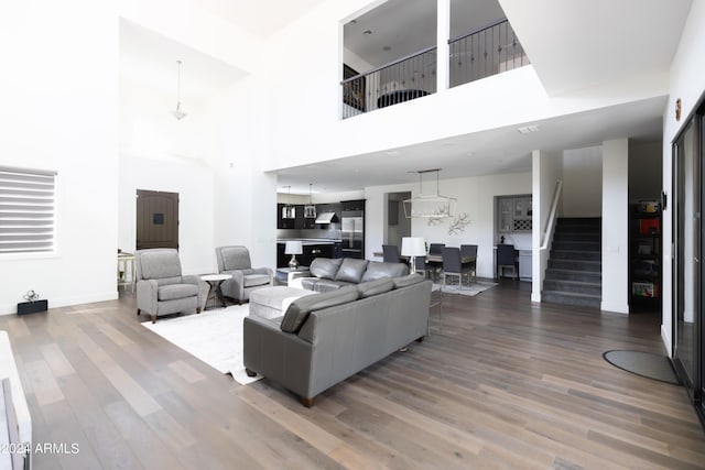 living room with wood-type flooring and a towering ceiling