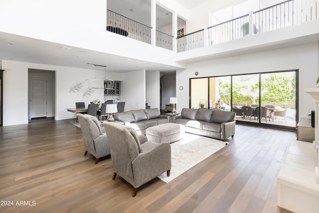 living room with a towering ceiling and hardwood / wood-style flooring