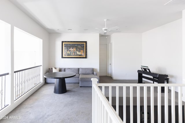 carpeted living room with ceiling fan