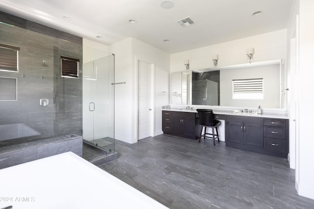 bathroom featuring a shower with door and vanity