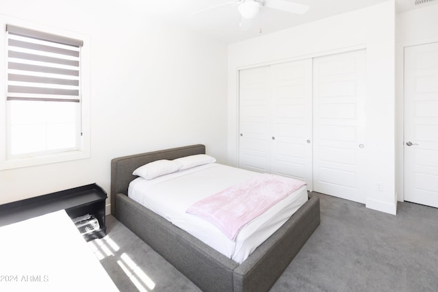 bedroom with dark colored carpet, a closet, and ceiling fan