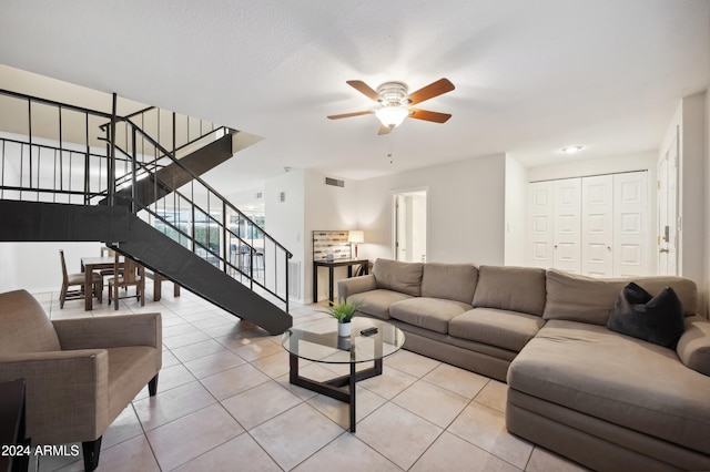 tiled living room featuring ceiling fan and a textured ceiling