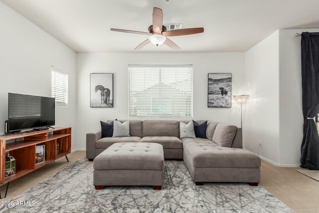 living room featuring a ceiling fan, carpet flooring, and baseboards