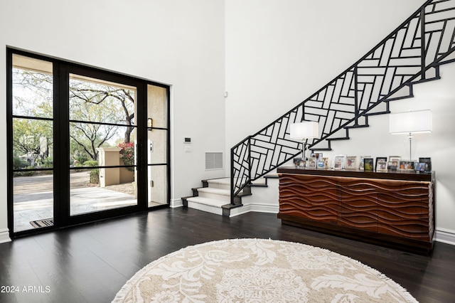 entrance foyer featuring hardwood / wood-style floors and a towering ceiling