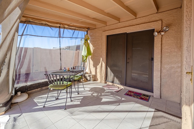 sunroom featuring beam ceiling