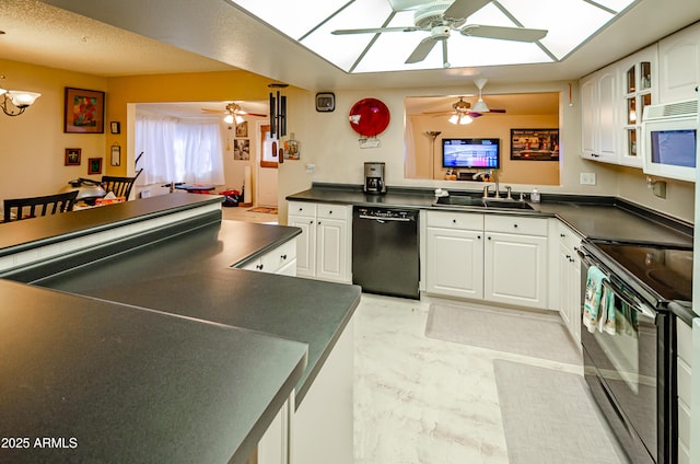 kitchen featuring ceiling fan with notable chandelier, white cabinets, black appliances, sink, and kitchen peninsula