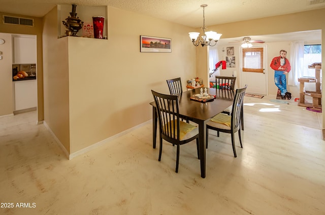 dining area featuring ceiling fan with notable chandelier and a textured ceiling