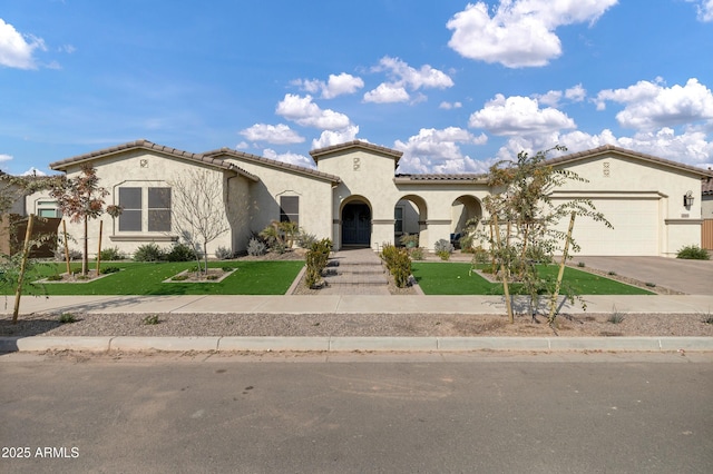 mediterranean / spanish home with a garage and a front yard