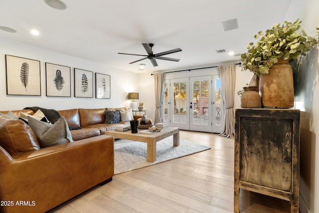 living room featuring french doors, ceiling fan, and light wood-type flooring