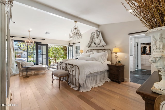 bedroom featuring access to exterior, vaulted ceiling with beams, a notable chandelier, and light hardwood / wood-style flooring