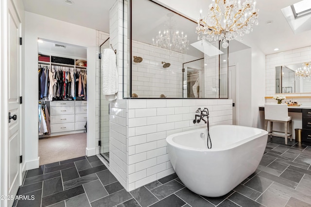 bathroom with an inviting chandelier, backsplash, tile walls, vanity, and plus walk in shower