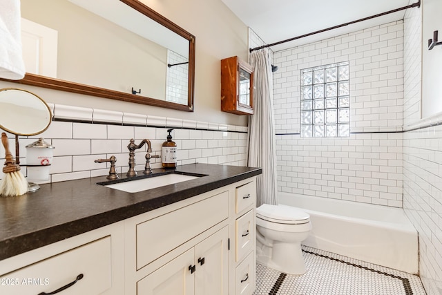 full bathroom featuring tile walls, shower / bath combination with curtain, vanity, toilet, and tile patterned floors