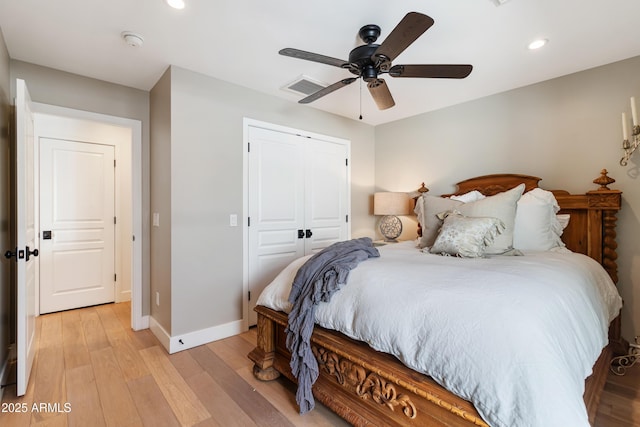 bedroom with light hardwood / wood-style flooring, a closet, and ceiling fan