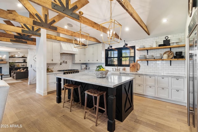 kitchen featuring white cabinetry, pendant lighting, a kitchen breakfast bar, and a center island