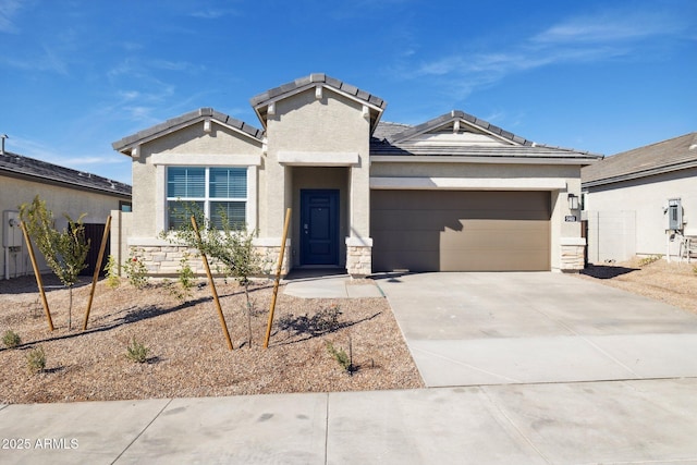 view of front of home featuring stone siding, stucco siding, an attached garage, and concrete driveway