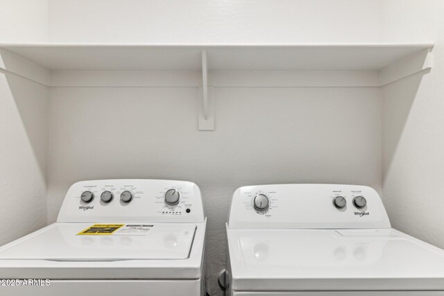 clothes washing area featuring washer and clothes dryer and laundry area