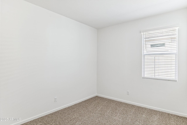 unfurnished room featuring baseboards and carpet