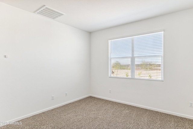 carpeted spare room with visible vents and baseboards