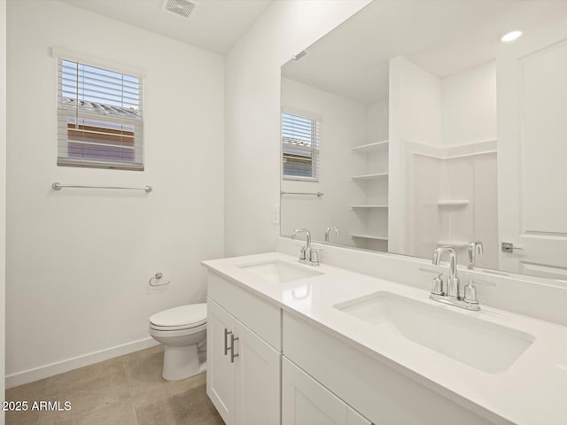 bathroom with toilet, vanity, and plenty of natural light