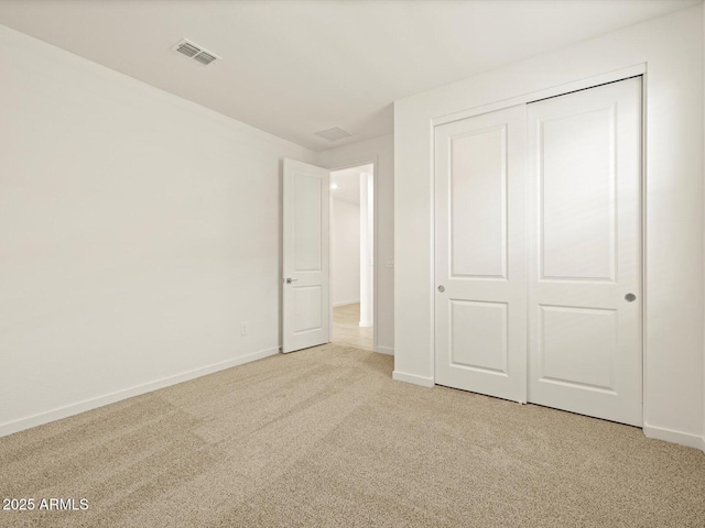 unfurnished bedroom featuring a closet and light carpet