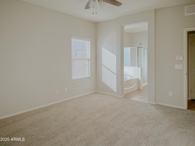 empty room featuring ceiling fan and light carpet