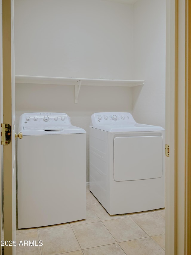 laundry area featuring washing machine and dryer and light tile patterned flooring