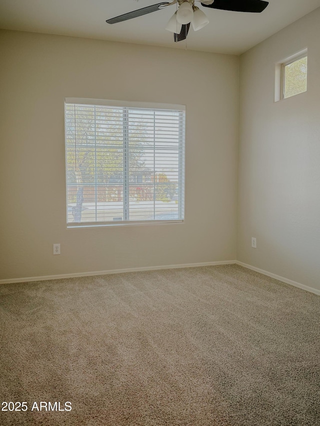 carpeted spare room featuring ceiling fan