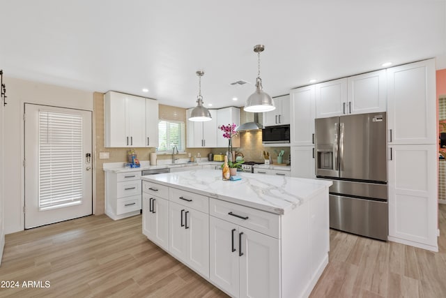 kitchen with a kitchen island, stainless steel fridge with ice dispenser, black microwave, and white cabinets