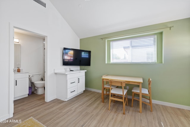 dining space with vaulted ceiling and light hardwood / wood-style flooring