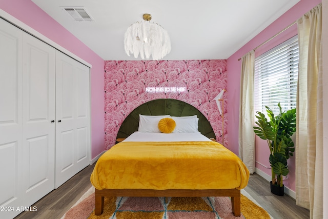 bedroom featuring hardwood / wood-style flooring, a closet, and a notable chandelier