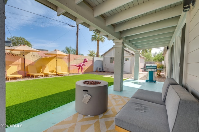 view of patio featuring a fire pit, an outbuilding, and grilling area