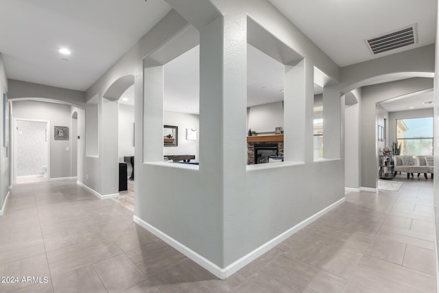 hall with arched walkways, tile patterned flooring, baseboards, and recessed lighting