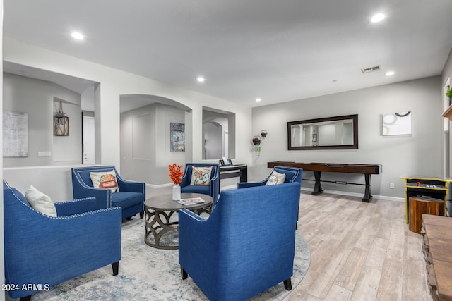 living area featuring wood finished floors, arched walkways, recessed lighting, and baseboards