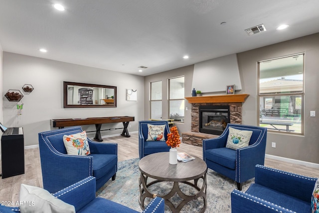 living room featuring wood finished floors, plenty of natural light, baseboards, a fireplace, and recessed lighting