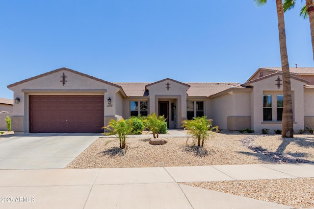 ranch-style house with stucco siding, a garage, concrete driveway, and a tile roof