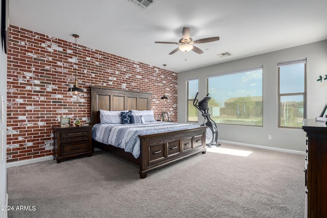 carpeted bedroom with baseboards, brick wall, and ceiling fan