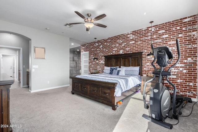 carpeted bedroom with arched walkways, baseboards, brick wall, and a ceiling fan