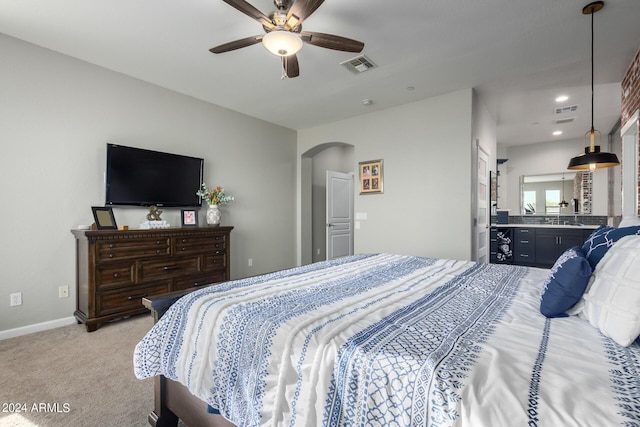 bedroom with arched walkways, light carpet, a sink, baseboards, and recessed lighting
