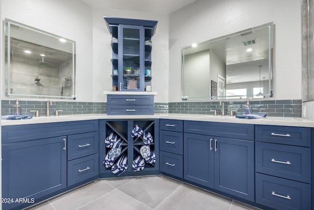 full bath featuring tasteful backsplash, tile patterned flooring, vanity, and a tile shower