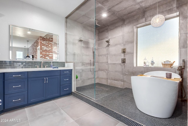 full bathroom featuring a walk in shower, a freestanding bath, vanity, tile patterned flooring, and decorative backsplash