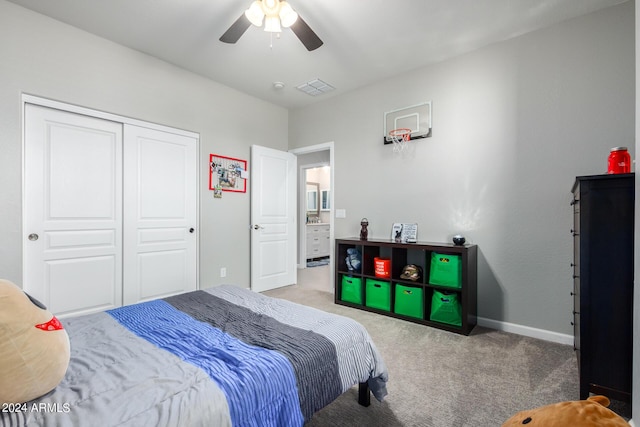 carpeted bedroom with a closet, baseboards, and a ceiling fan