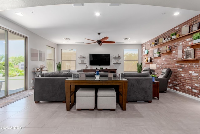 living area featuring brick wall, ceiling fan, baseboards, and recessed lighting