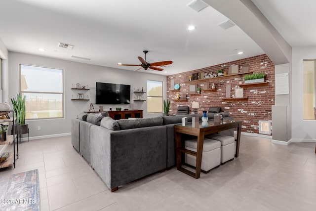 living area featuring ceiling fan, brick wall, baseboards, recessed lighting, and light tile patterned floors