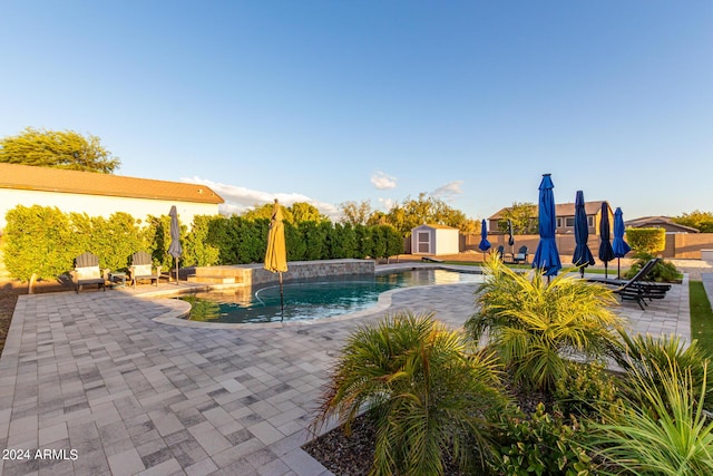 swimming pool with a storage unit, a patio, and an outdoor structure