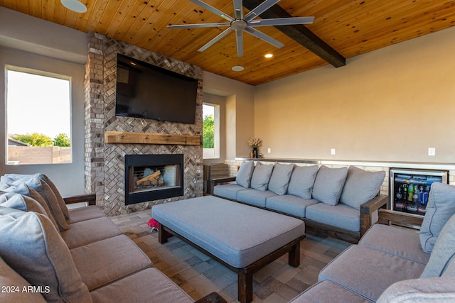 living room with wood ceiling, ceiling fan, recessed lighting, a multi sided fireplace, and beam ceiling